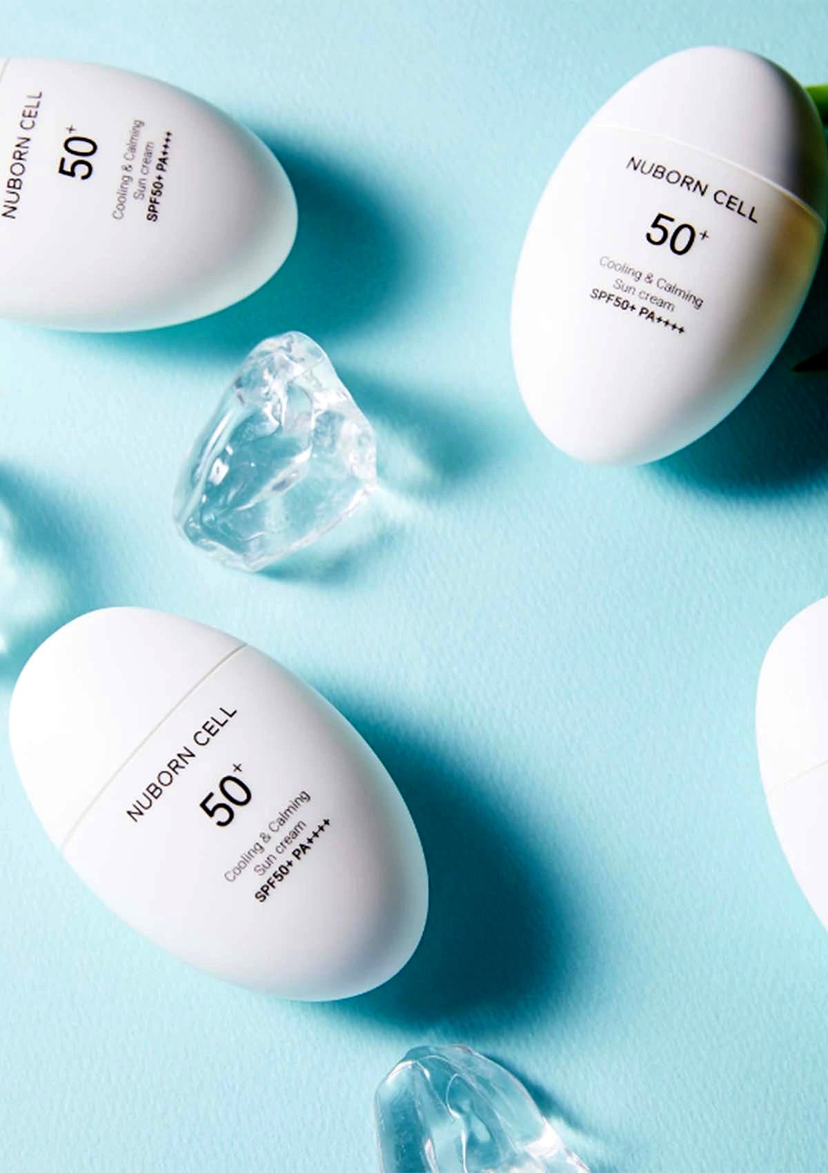 BLANC DUBU white sunscreen bottles on a cooling blue backdrop with ice